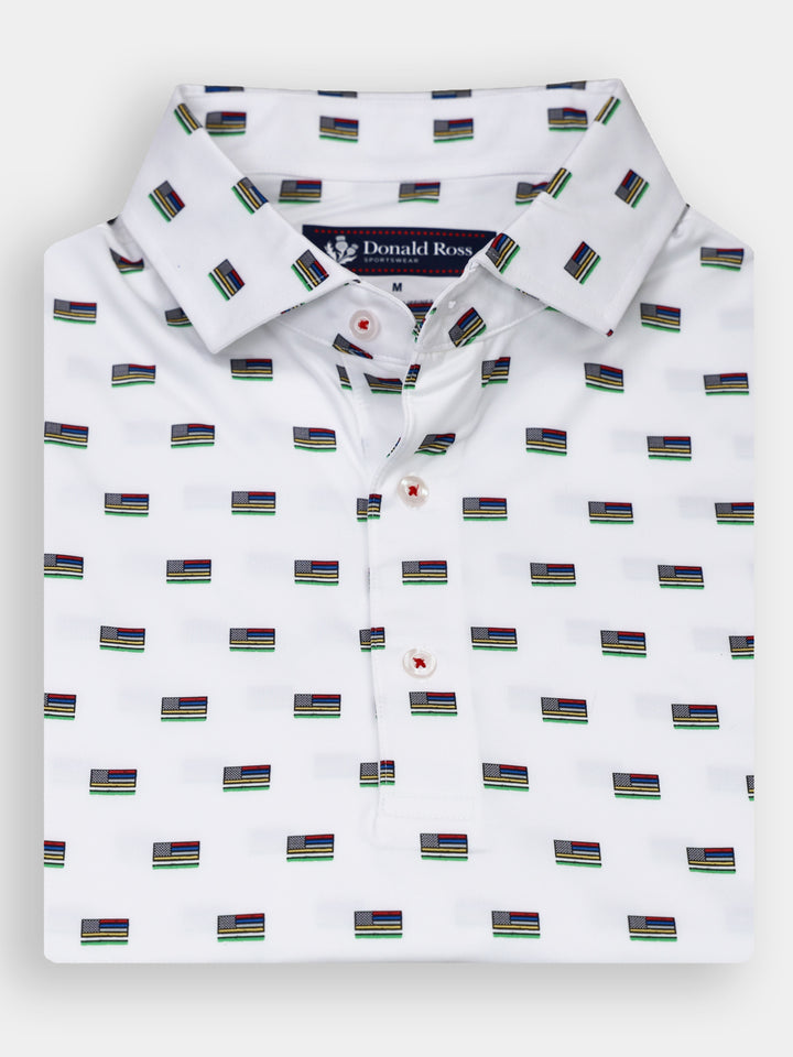 A white collared shirt is folded neatly and features a repeating pattern of small flags in various colors.
