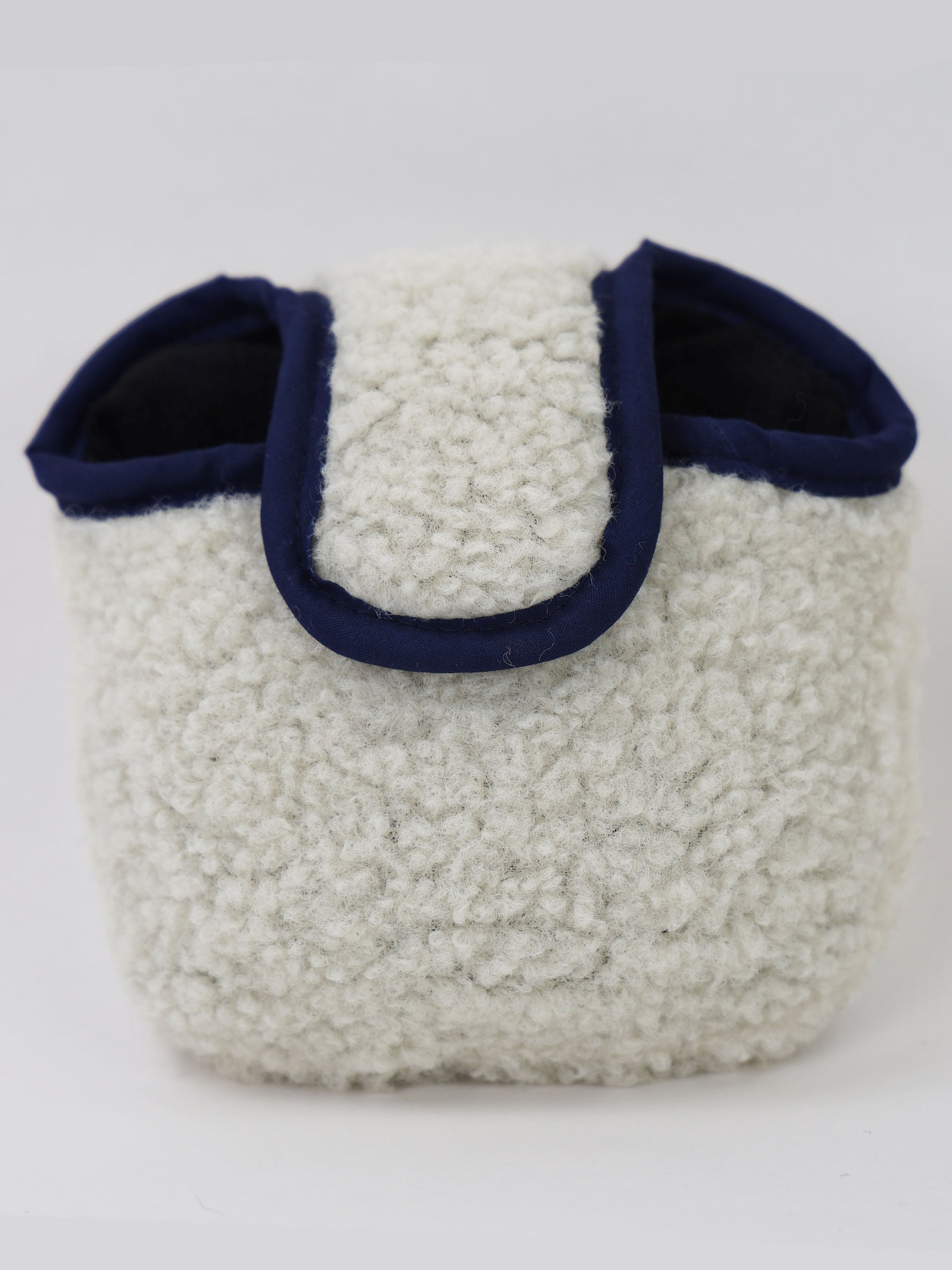 Cream-colored textured tote bag with navy blue handles displayed against a white background.