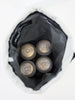 Four aluminum beverage cans with embossed logos rest inside a black mesh bag against a white background.