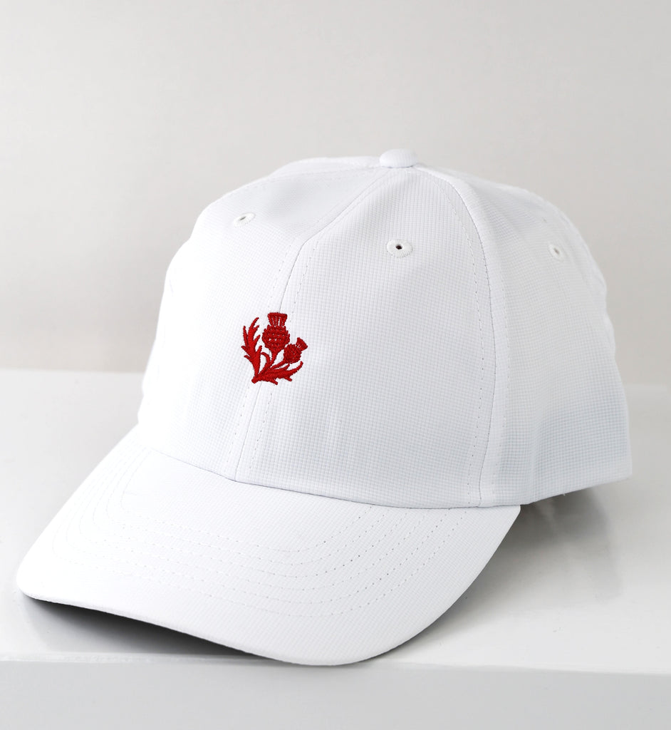 White baseball cap with red thistle embroidery on the front.