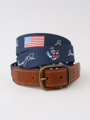 Navy canvas belt with American flag and patriotic embroidery paired with a cognac leather strap and antique brass buckle.