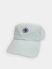 Light gray baseball cap with a small, dark blue embroidered thistle emblem on the front. The cap has visible stitching and is set against a plain white background