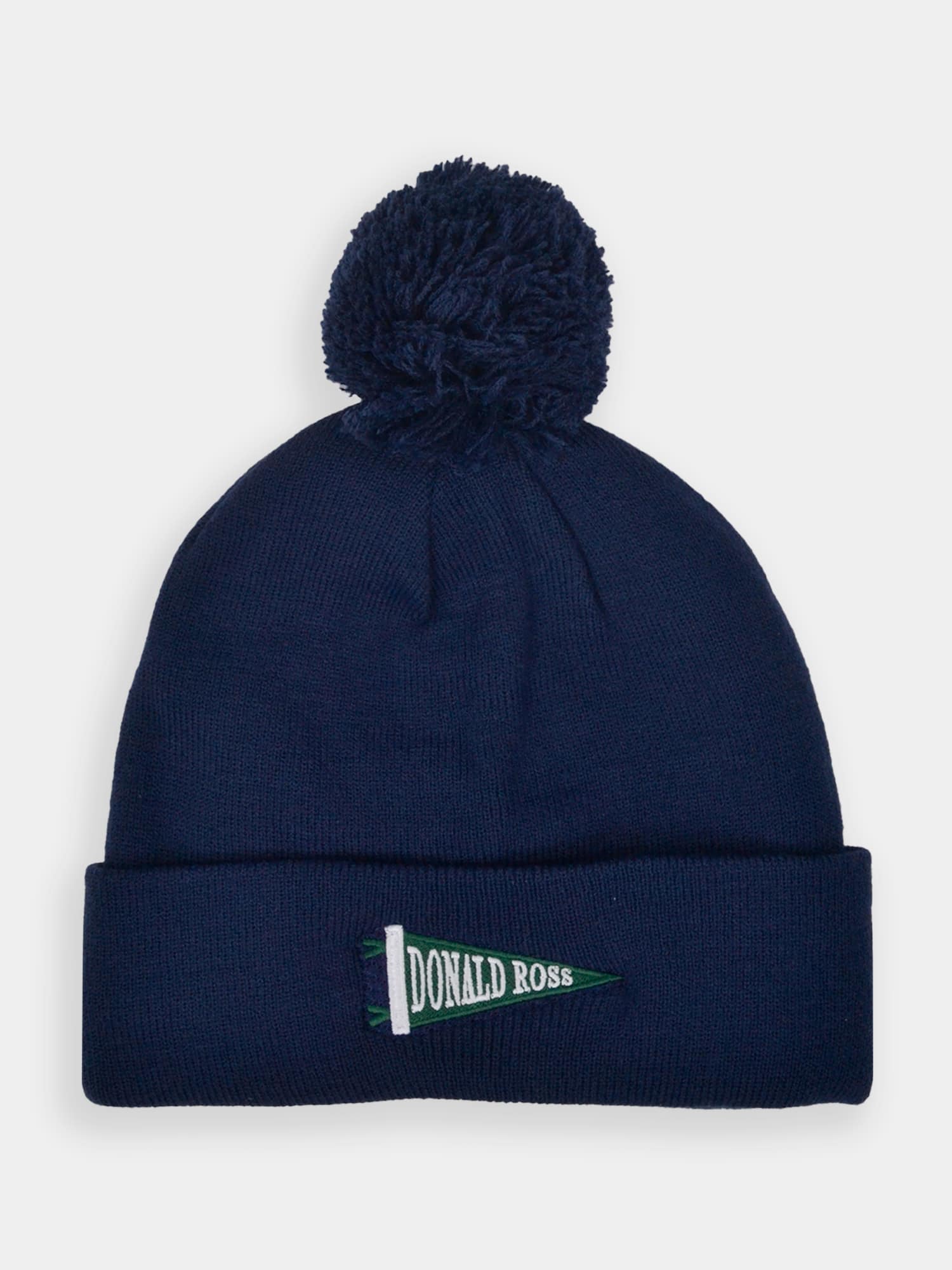 A navy blue knit beanie with a pom-pom on top. The turned-up brim features a green pennant with "Donald Ross" embroidered in white
