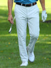 Two men walk on a lush golf course, each holding a club. They're wearing blue shirts and white pants, smiling and engaging in a lighthearted conversation