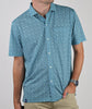 Man wearing a turquoise short-sleeve polo shirt with a small-scale geometric pattern, paired with khaki pants.