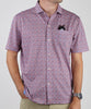 Man wearing a short-sleeve button-up shirt in a red and blue floral print pattern with a black pocket detail.