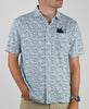 Man wearing a short-sleeve blue and white patterned polo shirt with a black pocket detail and neutral khaki shorts.