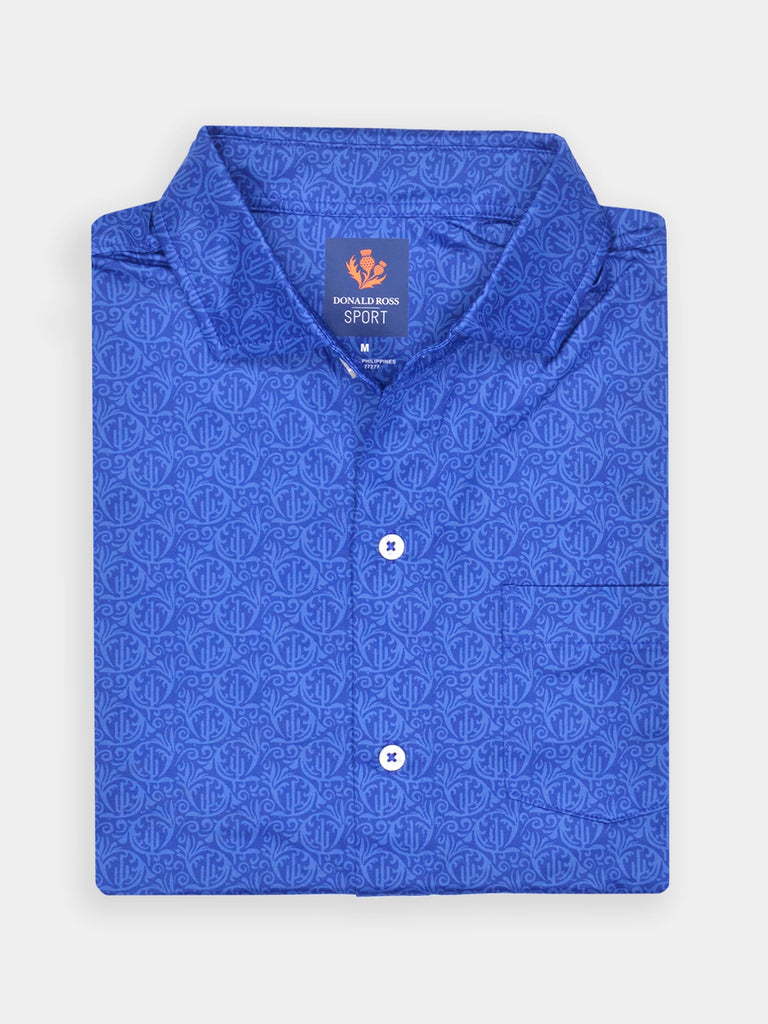 Folded blue golf dress shirt with an intricate swirling pattern, featuring white buttons