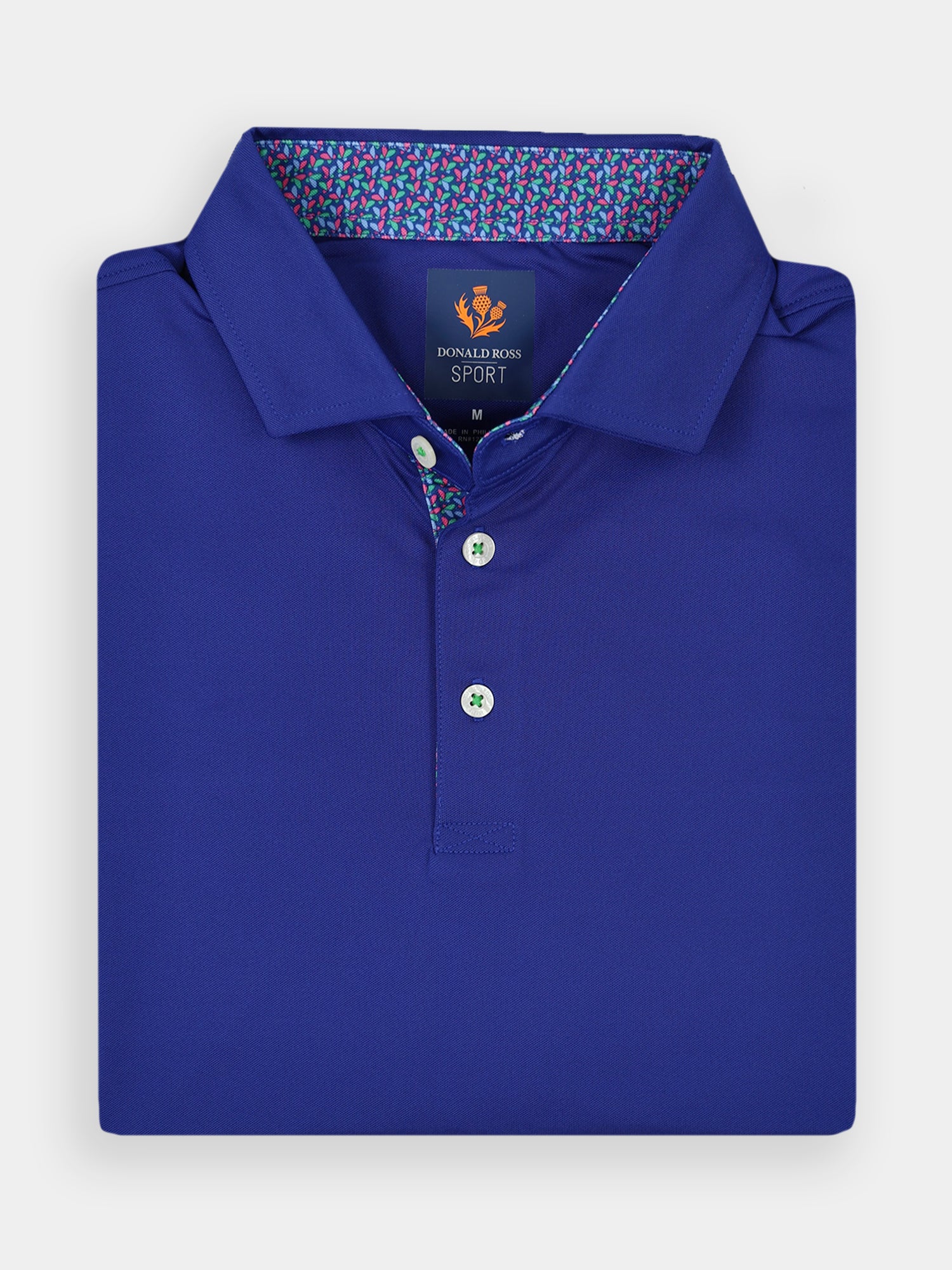 Folded royal blue polo shirt with contrasting patterned collar lining and three buttons