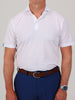 A person in a white golf polo shirt and blue pants, wearing a brown belt and silver watch, stands against a plain background, conveying a casual, polished look.