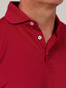 Close-up of a person wearing a red polo shirt with a partially unbuttoned collar. The fabric is textured, and the buttons are white with red stitching.
