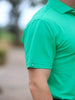 Close-up of a person wearing a bright green polo shirt