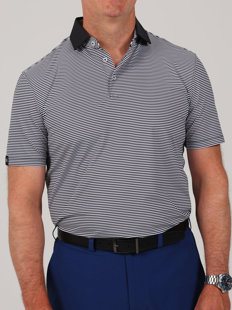 A neatly folded Owen performance jersey golf polo in black with white feeder stripes and a solid black collar.