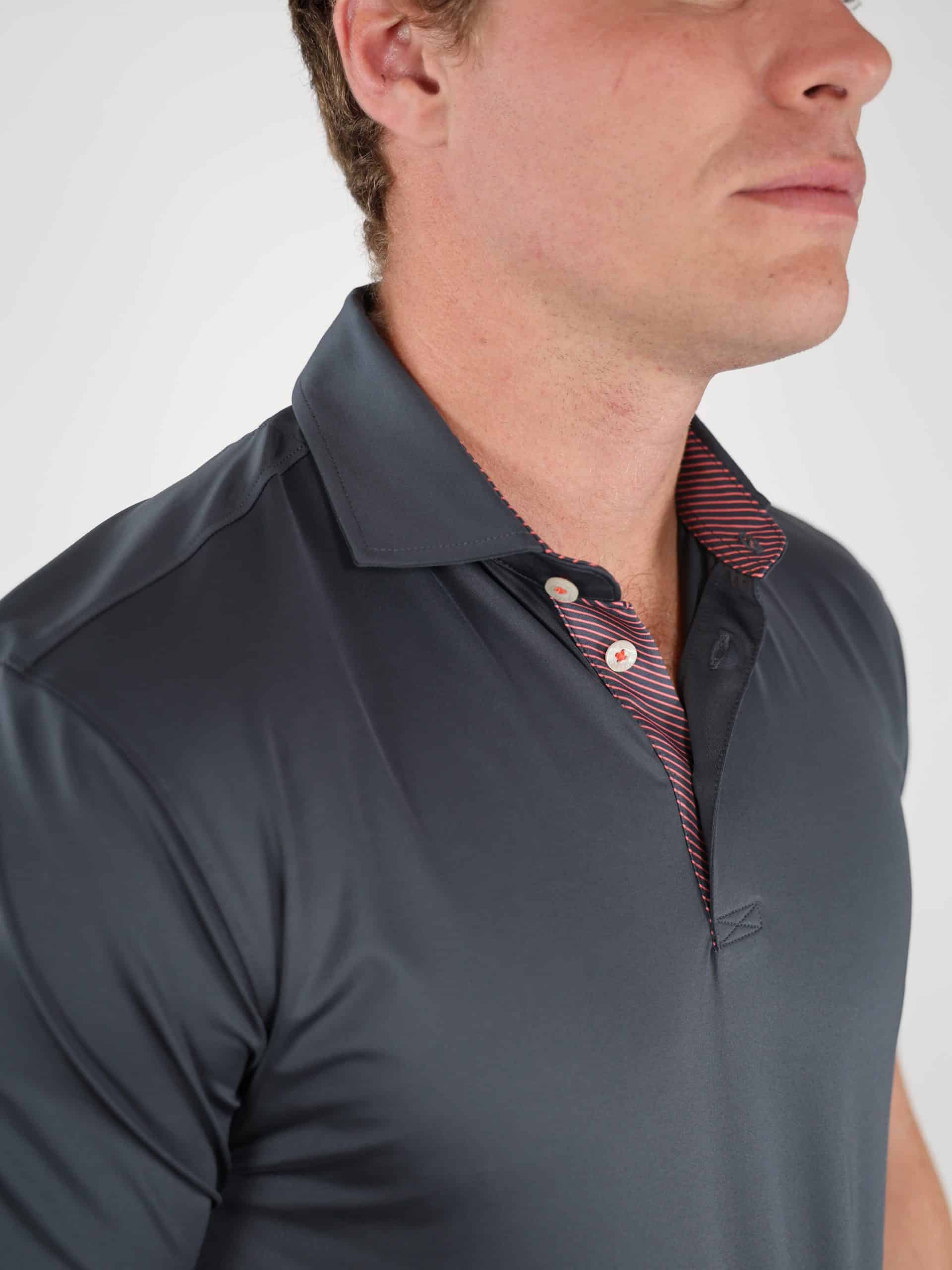 Man wearing a dark gray collared shirt with red-striped detail on the inside