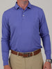 A man wearing a blue long-sleeve polo shirt and beige pants with a brown belt. The setting is neutral, focusing on the casual, stylish attire.