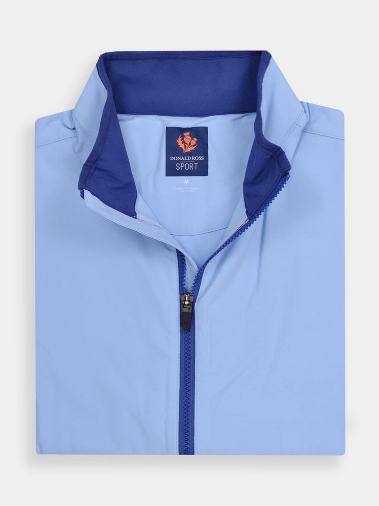 Folded light blue jacket with a dark blue inner collar and zipper, featuring premium fabrics