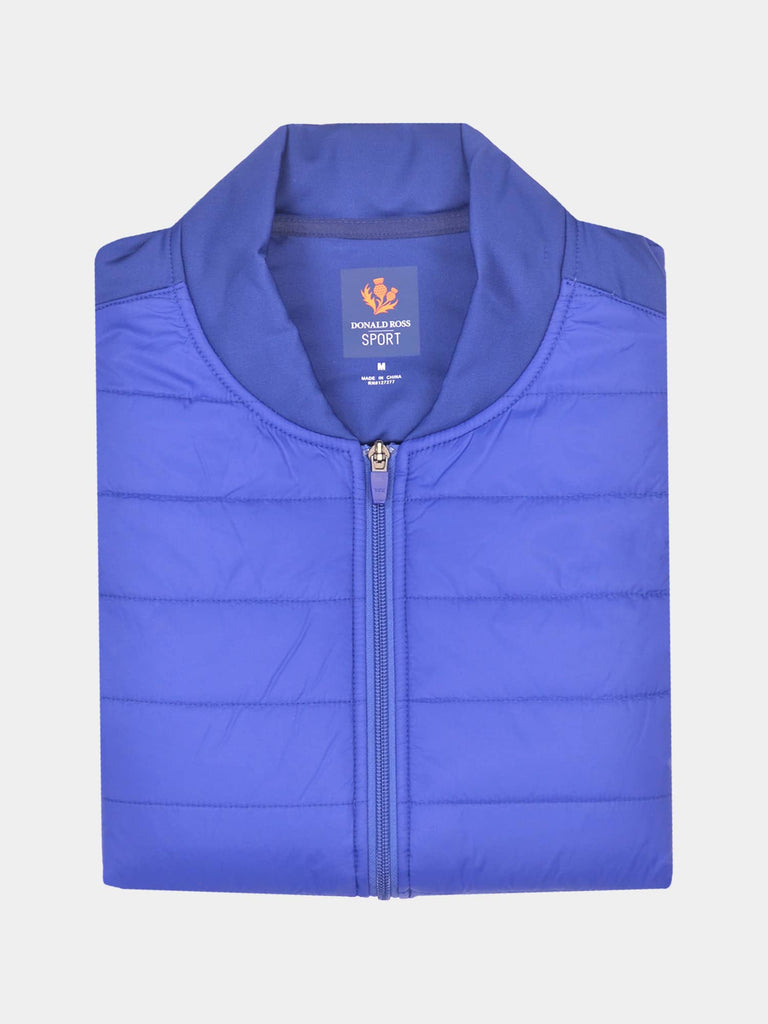 Folded royal blue quilted jacket with a visible label inside the collar