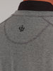 Close-up of a gray pullover jacket, featuring a small black embroidered symbol at the upper back. The texture is soft and the tone is sophisticated.