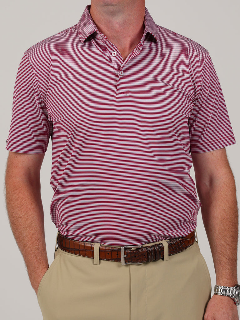 Man wearing a maroon and white striped polo shirt with beige pants and a brown belt. The tone is casual, evoking a relaxed and neat style.