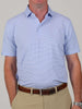Man wearing a light blue striped polo shirt tucked into beige pants with a brown belt. Arms are relaxed by his sides, conveying a casual tone.