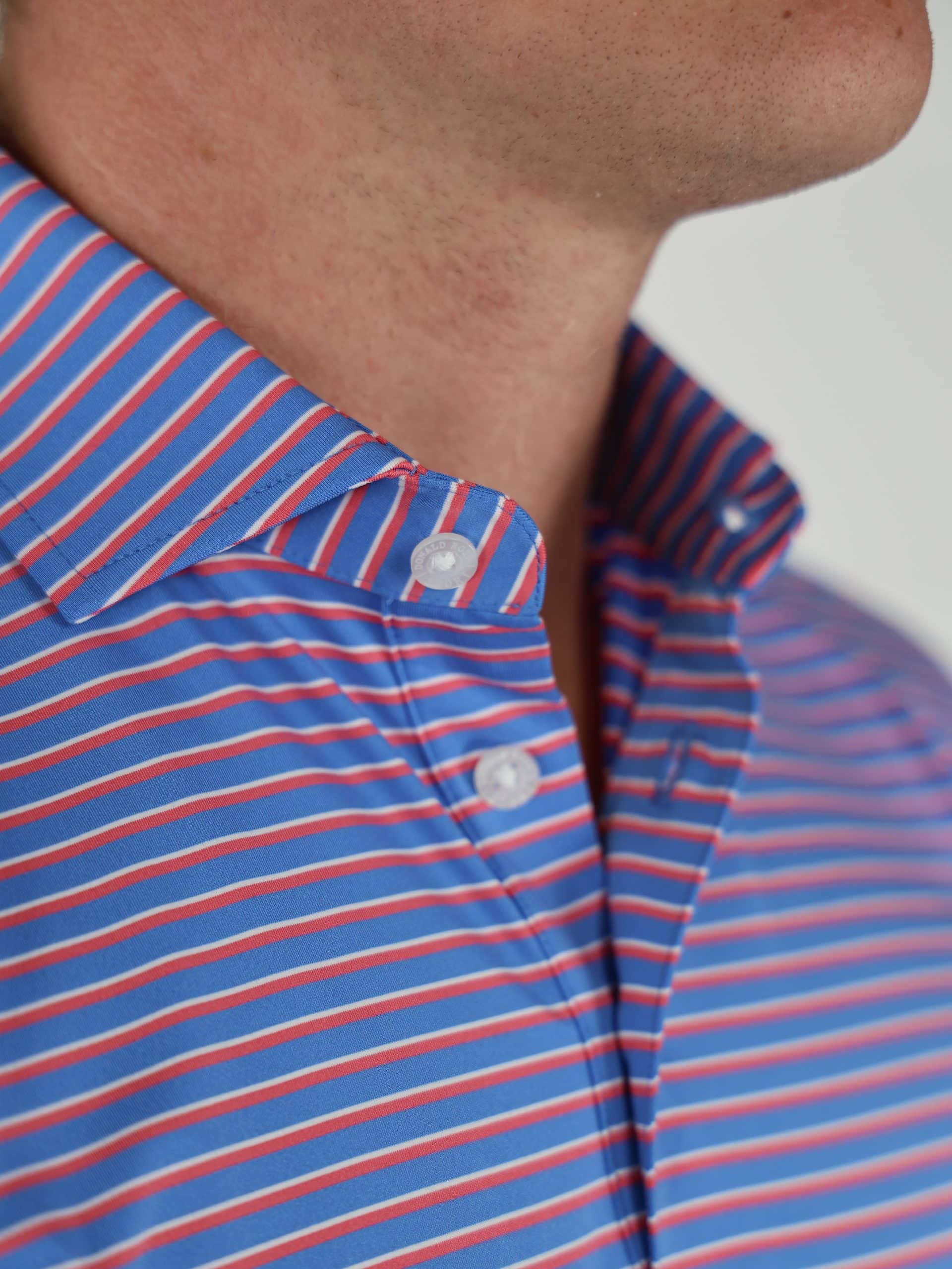 Close-up of a person wearing a blue, red, and white striped button-down shirt