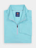 A neatly folded, light blue zip-up pullover with a high collar and a visible label on the inside