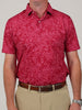A person wearing a red floral-patterned short-sleeve polo shirt, beige pants, and a brown leather belt. The tone is casual and stylish.