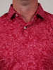 Close-up of a person wearing a red shirt with white floral patterns. The shirt is buttoned up, conveying a casual yet stylish appearance.