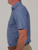 A man is shown in profile wearing a short-sleeved blue patterned shirt and beige pants.