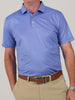 A man in a light blue patterned polo shirt and khaki pants with a brown belt. He stands against a neutral background, conveying a casual yet neat style.