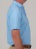 Side profile of a person wearing a light blue polo shirt and beige pants. The shirt has a subtle golf club pattern, and the tone is neutral and casual.