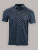A navy blue patterned polo shirt featuring small light blue shark motifs. It has a button-down collar and short sleeves against a neutral gray background.
