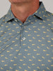 A man wearing a blue collared shirt with a playful shark pattern. The shirt is buttoned up, giving a casual yet stylish vibe.