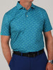 A man wearing a blue polo shirt with a subtle shark pattern paired with dark blue pants and a black belt. He has one hand in his pocket, creating a relaxed look.