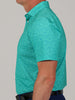 Man wearing a teal, football patterned golf polo shirt and dark blue pants, shown from the side. The shirt features a small, intricate leaf design.