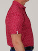 Side profile of a person wearing a vibrant red short-sleeve shirt with a white football pattern.