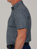 A person is shown from the side wearing a fitted, short-sleeve, button-up shirt with a blue and black camoflauge pattern. The background is plain gray.