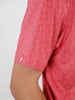 Close-up of a person wearing a red short-sleeved shirt with an intricate circular pattern