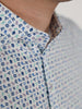 Close-up of a man wearing a white poloshirt featuring colorful, small zodiac symbols pattern in blue, green, and purple