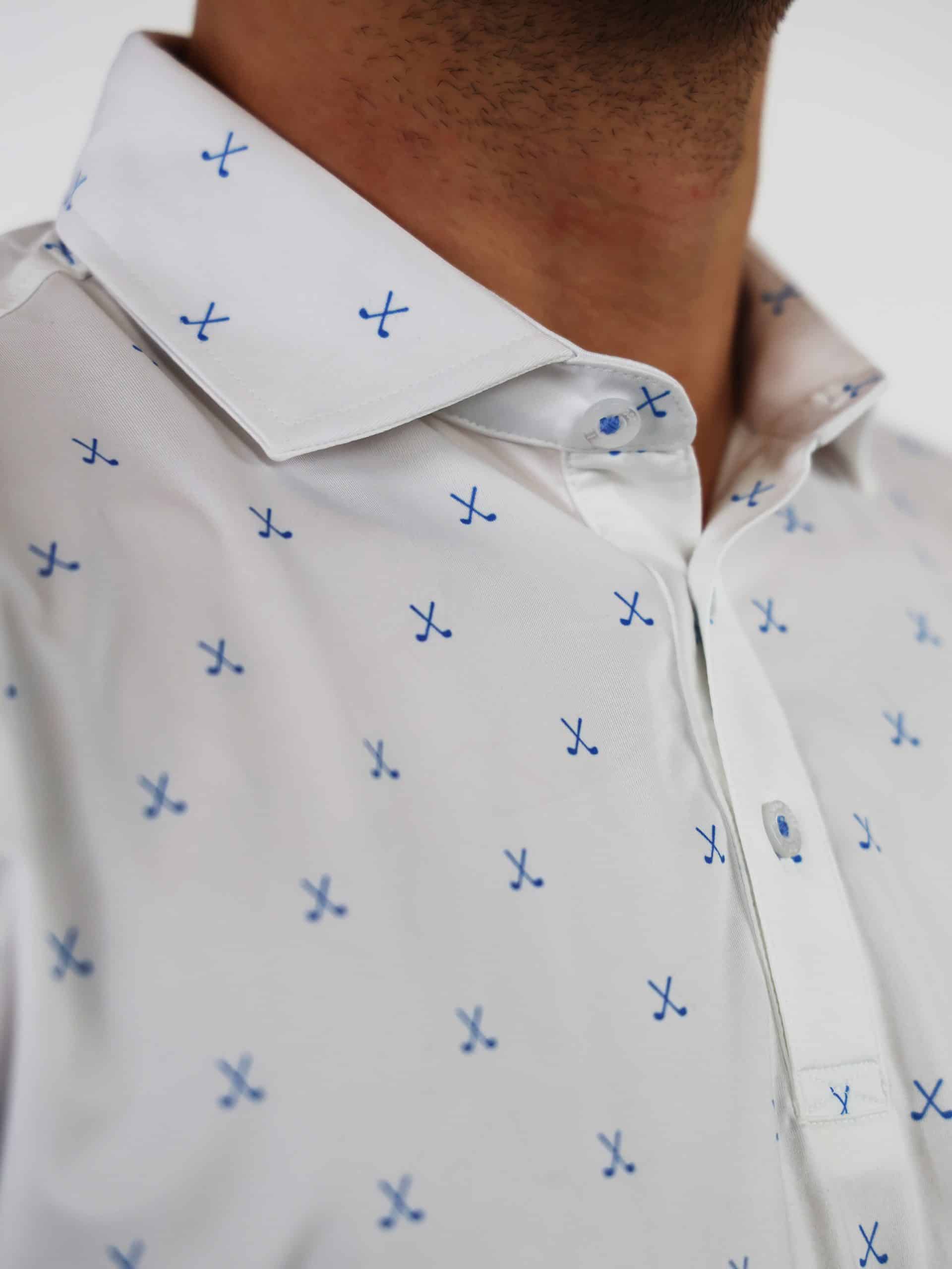 Close-up of a white shirt with small blue crossed golf club pattern, worn by a person