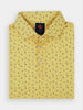 Yellow polo shirt with a folded collar featuring a tropical pattern of small black pineapples, palm trees, and dolphins