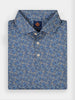 A folded blue polo shirt for golfers with a floral pattern in beige and white