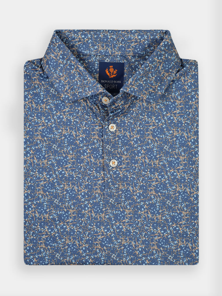 A folded blue polo shirt for golfers with a floral pattern in beige and white