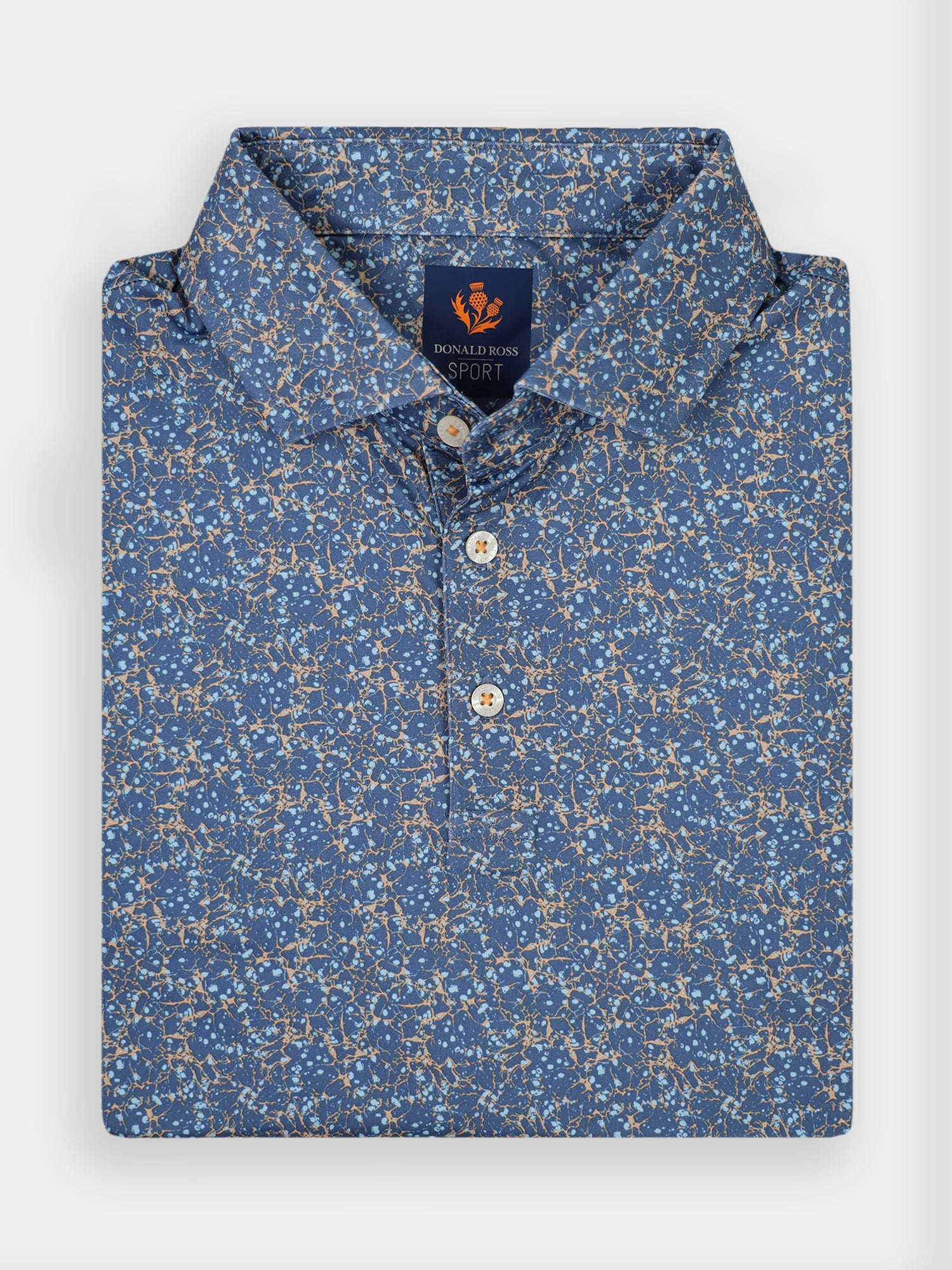 A folded blue polo shirt for golfers with a floral pattern in beige and white
