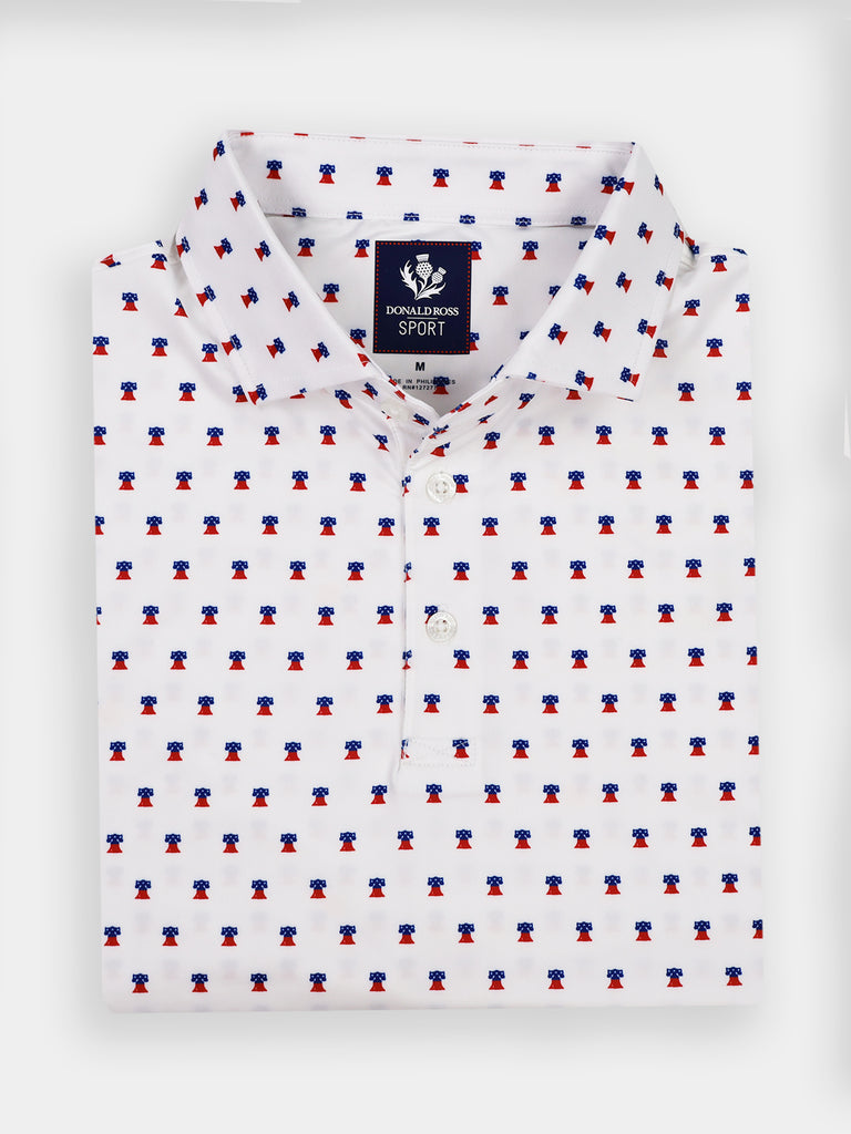 Folded white polo shirt with a small, all-over red and blue liberty bell pattern