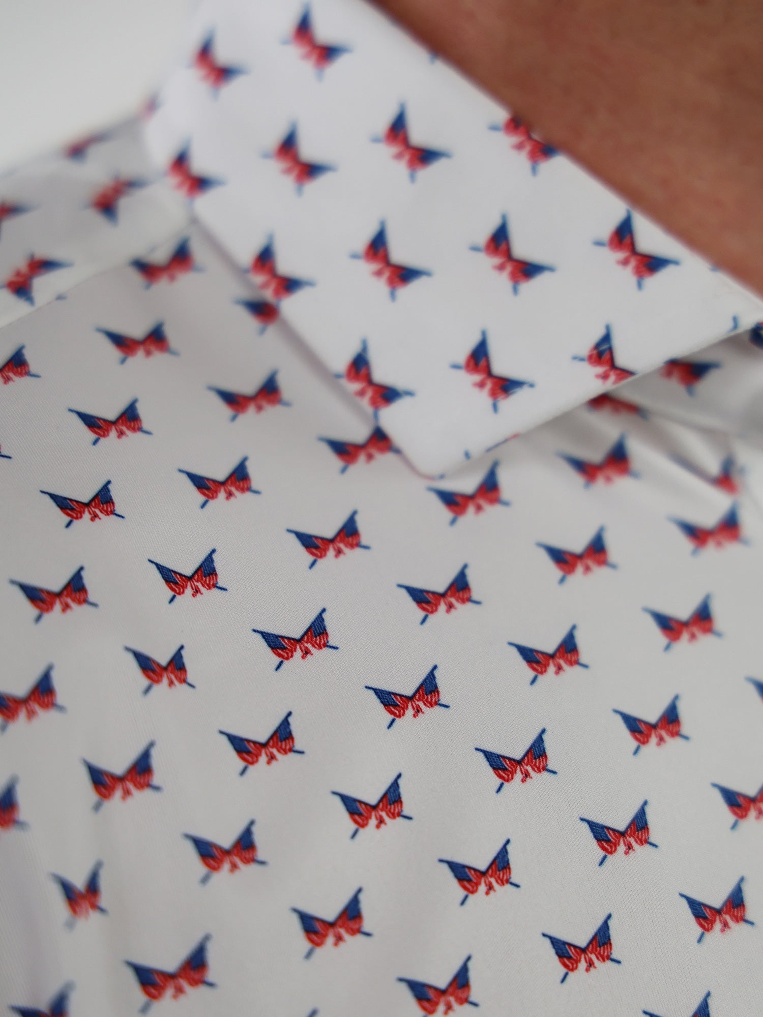 Close-up of a white shirt with a pattern of small, red and blue crossed flags
