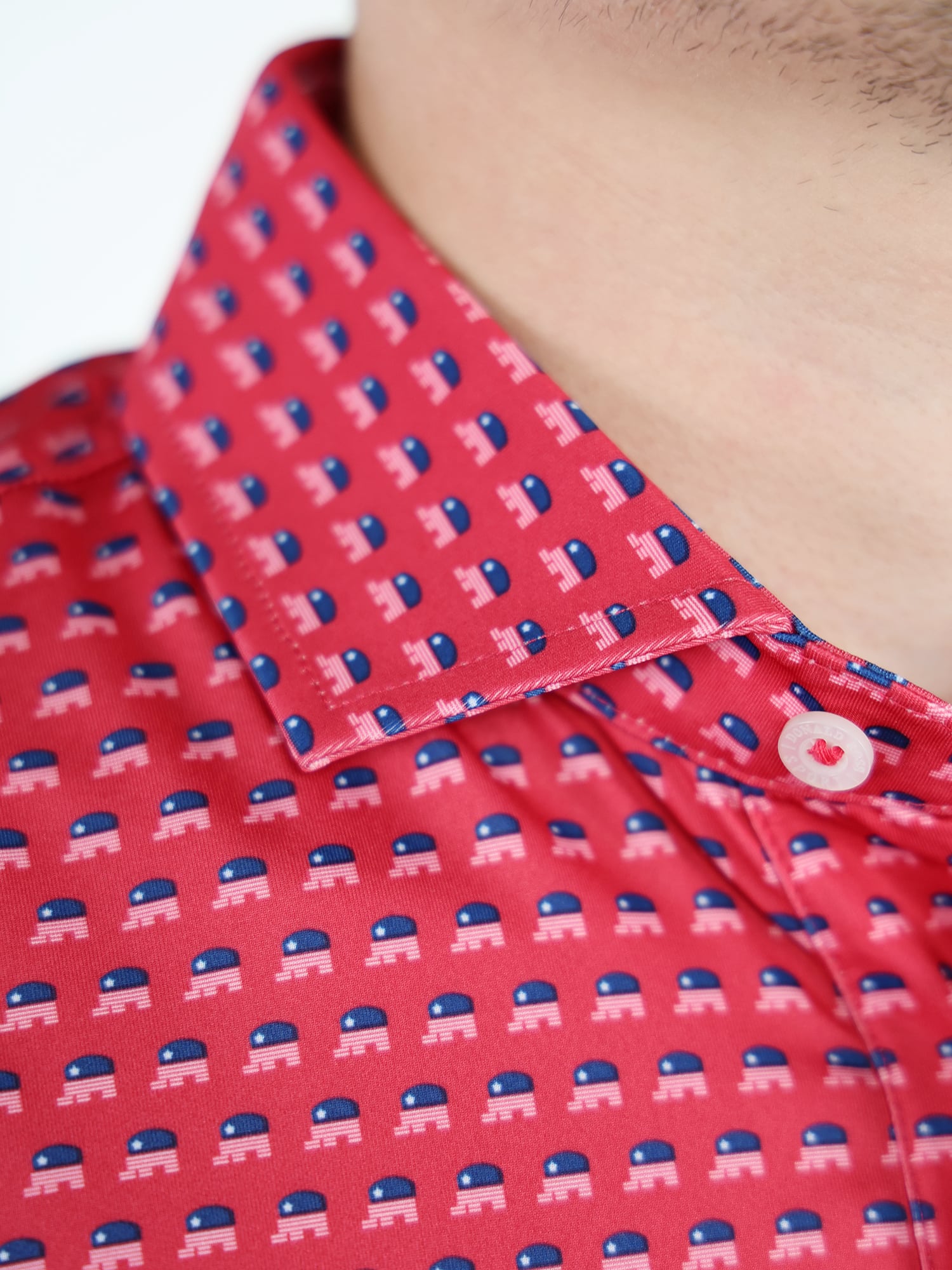 Close-up of a red dress shirt featuring a repeating pattern of republican elephants in blue and white