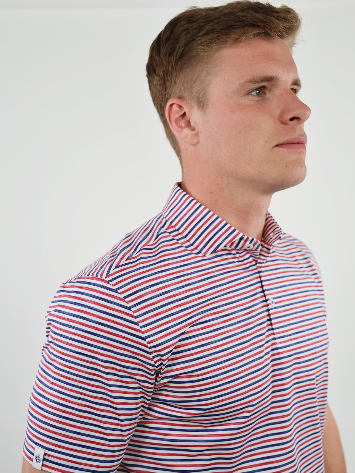 Man wearing patriotic golf polo shirt with red white and blue stripes