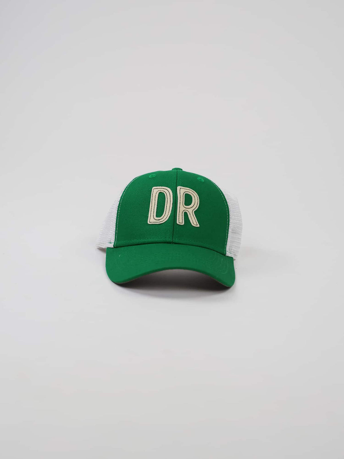 Green trucker hat with white mesh sides featuring large, bold letters "DR" in cream on the front