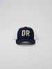 Navy blue and white trucker cap with "DR" in large stitched letters on the front